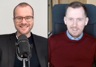 Split-screen video interview: left man wearing glasses speaks into a microphone; right man in a burgundy sweater wears wireless earbuds.