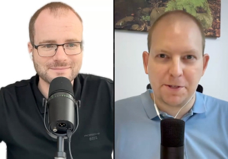 Split-screen video call with two men, each speaking into a microphone; left man wears glasses in black shirt, right man in blue polo with earphones behind a desk.