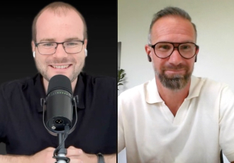 Split-screen video interview: left host in black shirt with microphone, right guest in white polo wearing glasses.
