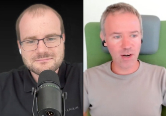 Split-screen video call: left man with glasses speaks into a large microphone; right man wearing earbuds sits against a light background with a green headrest.