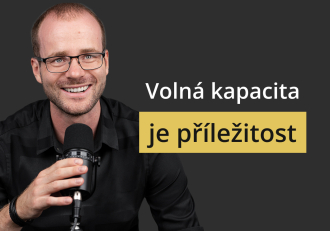 Man speaks into a microphone on the left with a dark background and a yellow banner reading 'je příležitost' — overlay text: 'Volná kapacita' (Czech: 'Available capacity is an opportunity').